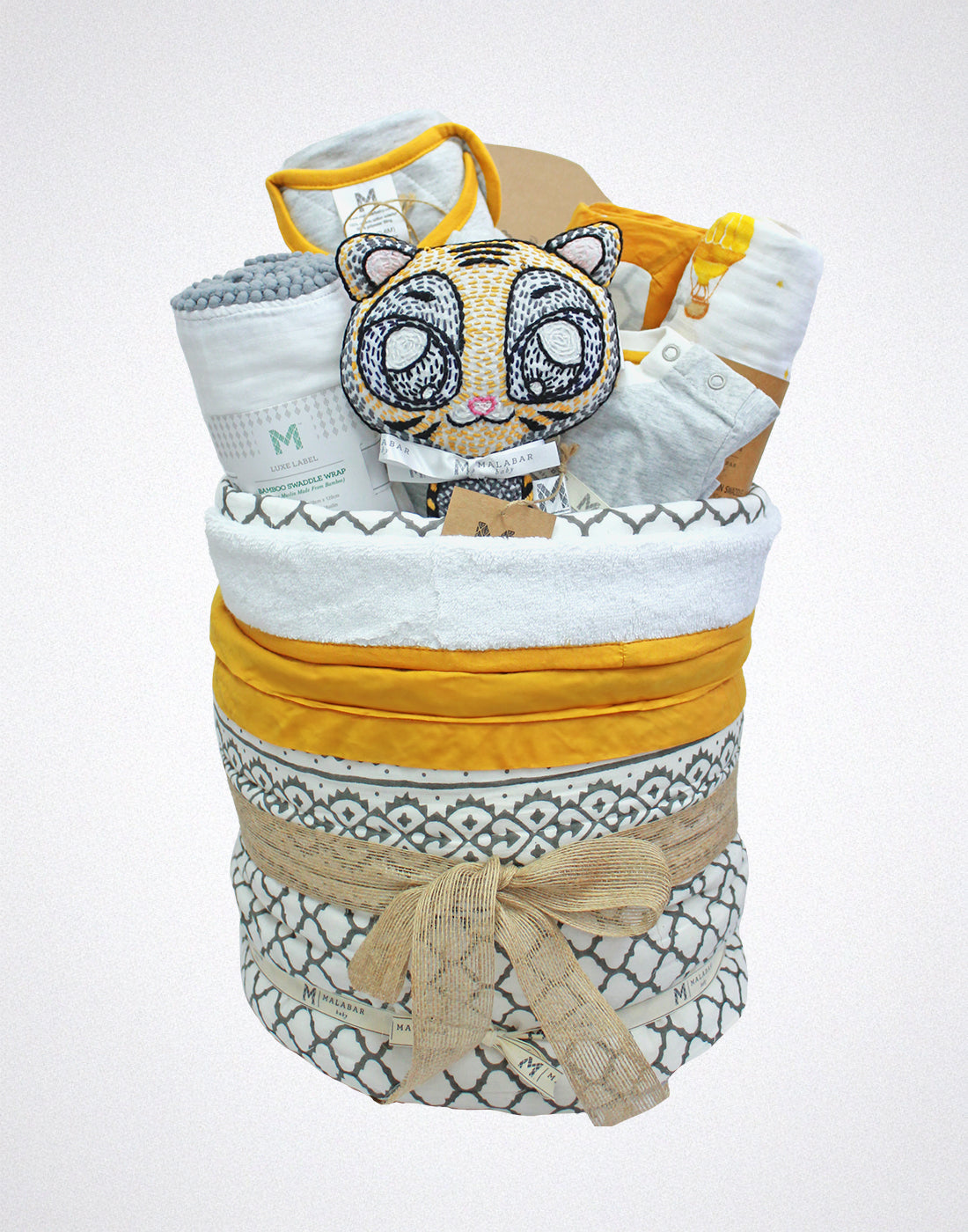 Malabar Baby luxury baby hamper with organic baby clothing, cozy blankets, and a plush stuffed animal.