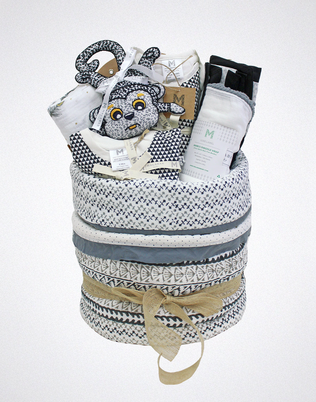 Malabar Baby luxury baby hamper with organic baby clothing, cozy blankets, and a plush stuffed animal.