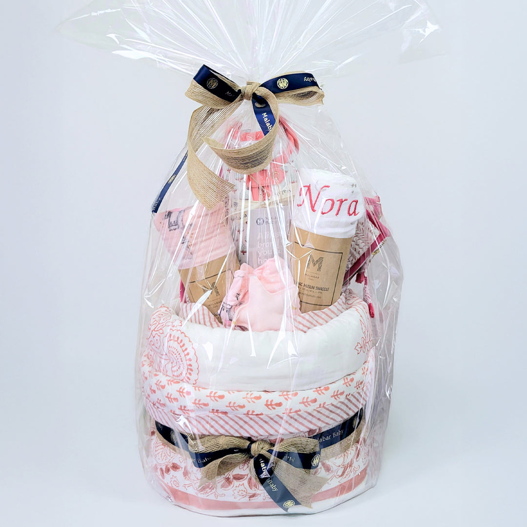 Luxury baby hamper featuring adorable clothing, plush toys, and decorative packaging from Malabar Baby, ideal for new parents.