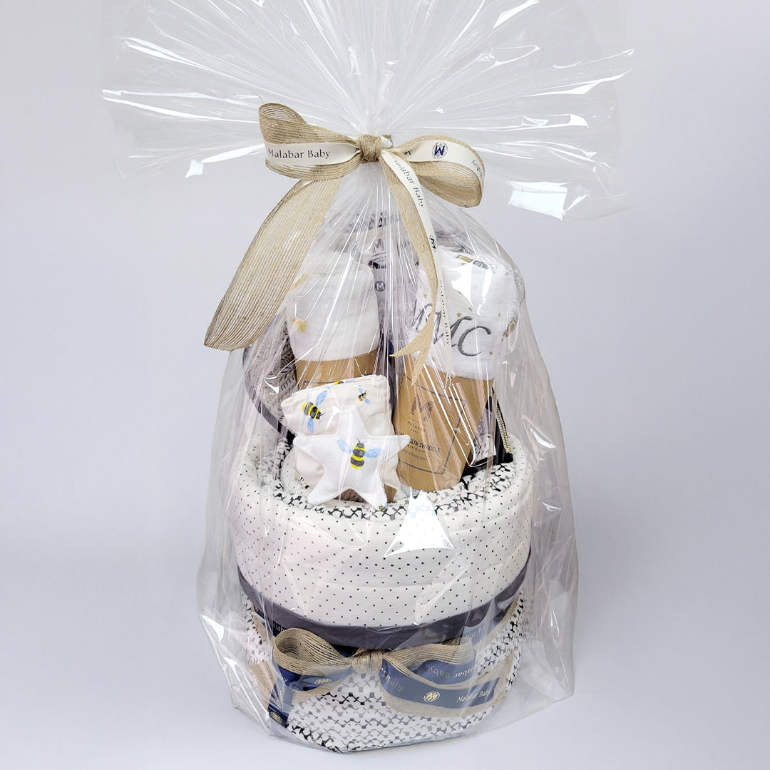 Luxury baby hamper featuring adorable clothing, plush toys, and decorative packaging from Malabar Baby, ideal for new parents.