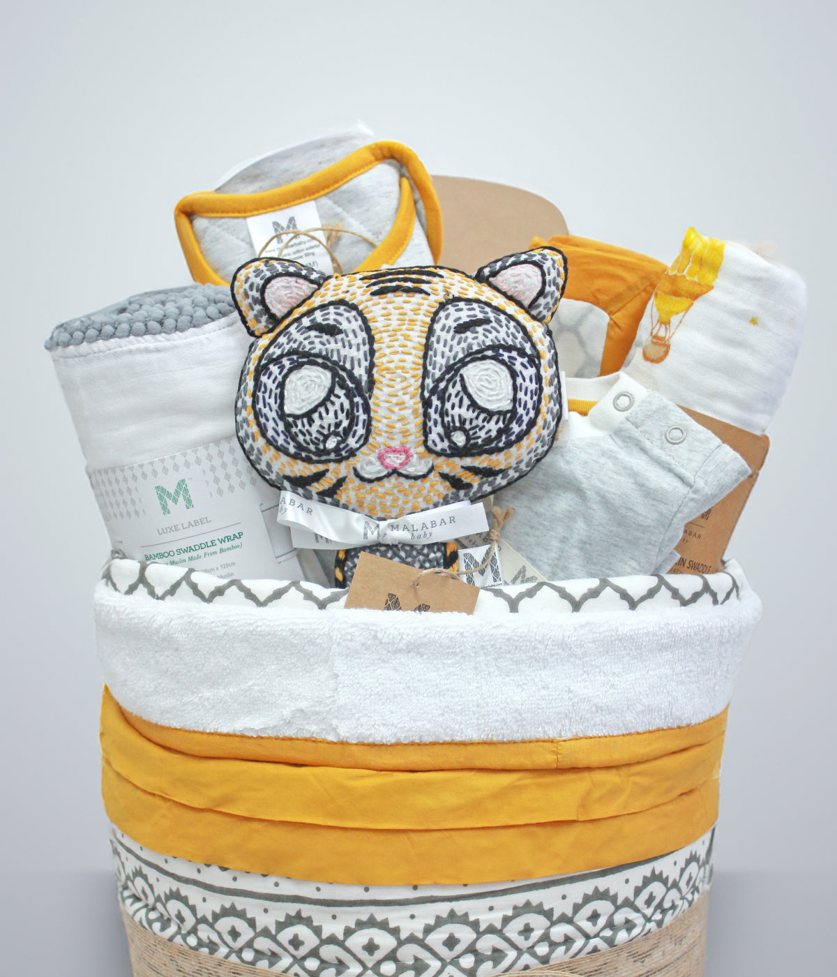 Personalized baby hamper with customized baby blanket, cute onesies, and plush toys for new parents.