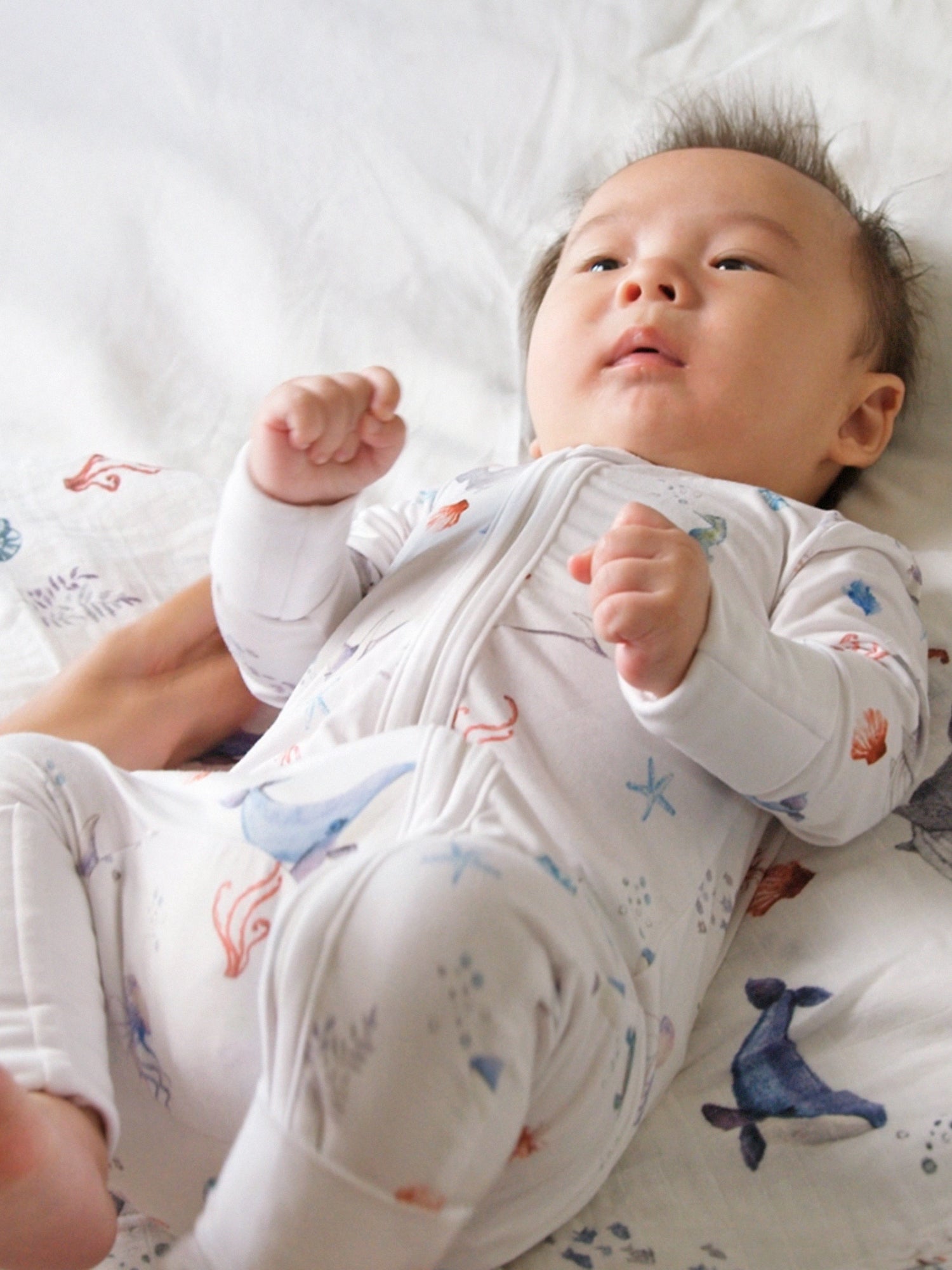 Under the Sea baby romper featuring playful ocean print, made from buttery soft bamboo cotton with a two-way zipper, foldover footie and mittens for warmth, eco-friendly dyes, and OEKO-TEX® Standard 100 certification. Perfect for newborns to 12 months, providing comfort, ease of dressing, and style for little explorers.
